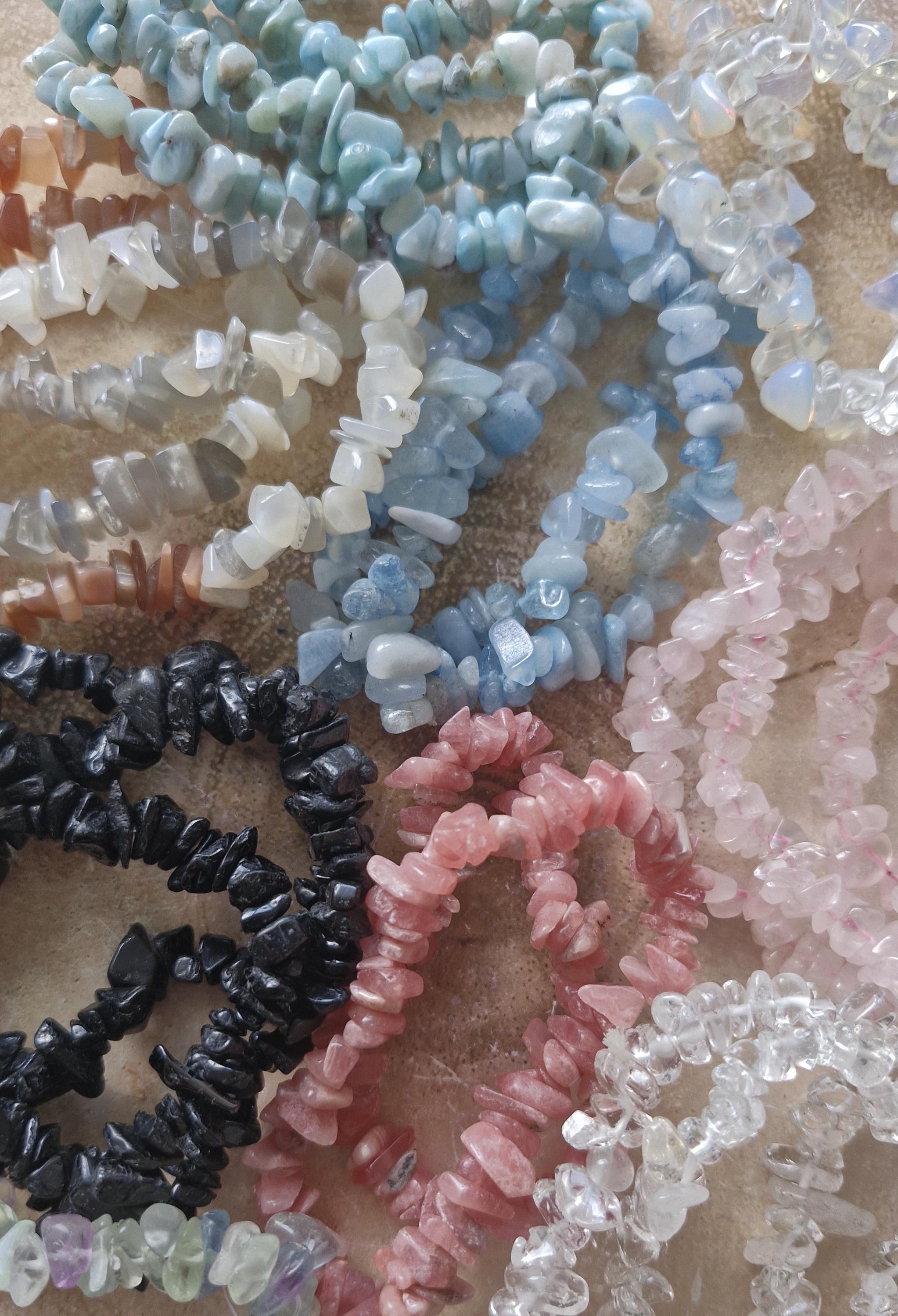 Variety of Natural Chipped Crystal Bracelets. Each one has a stretchy adjustable band.
